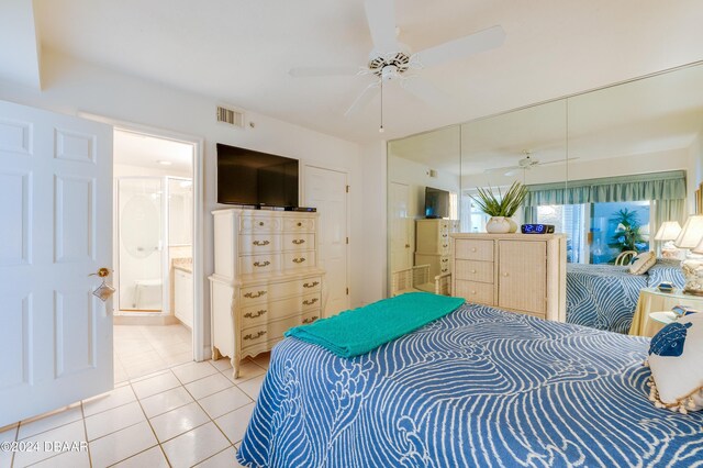 bedroom with tile patterned flooring, ensuite bath, and ceiling fan