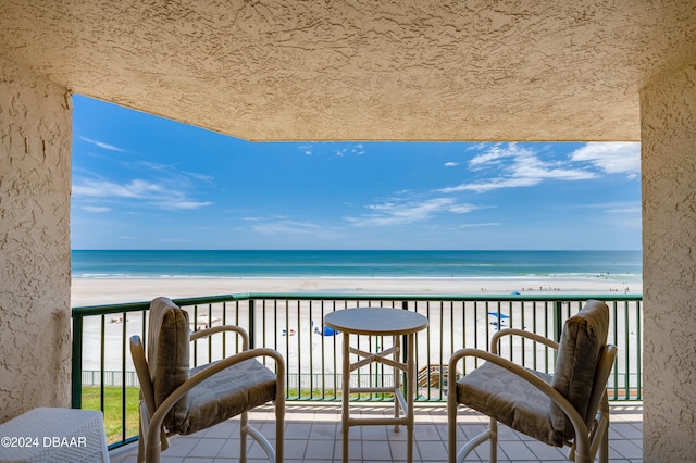 balcony featuring a water view and a view of the beach