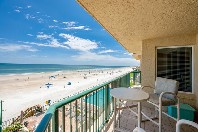 balcony with a water view and a beach view