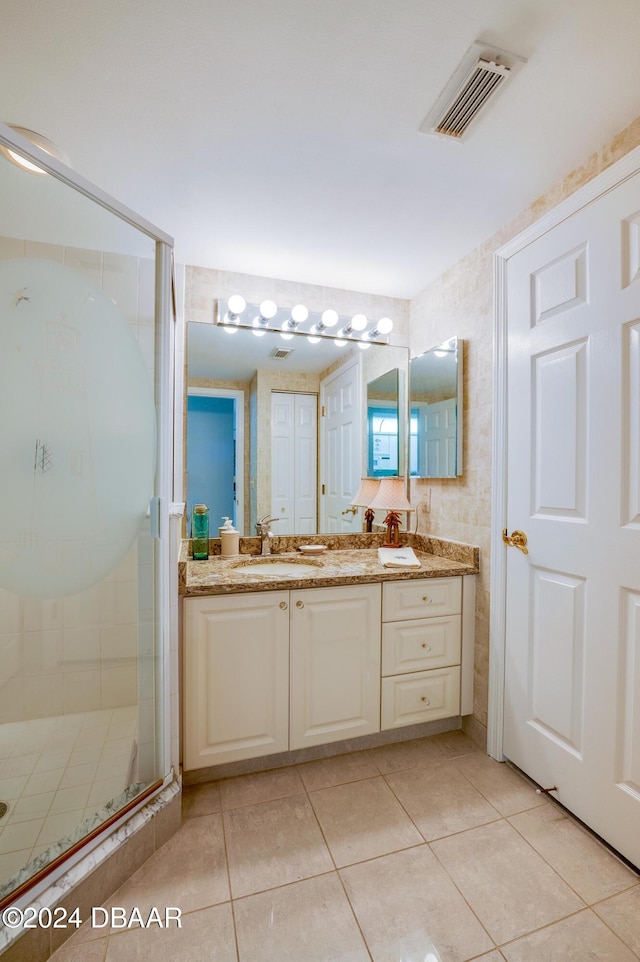 bathroom featuring vanity, a shower with door, and tile patterned floors