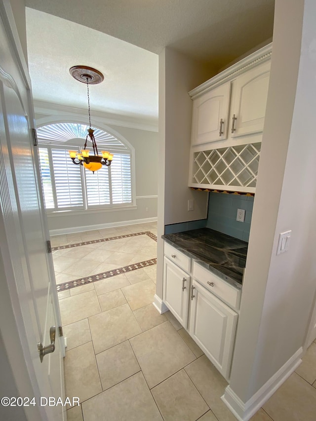 3 Tomoka View Dr, Ormond Beach, FL 32174 - kitchen featuring dark countertops, baseboards, light tile patterned floors, a chandelier, and white cabinetry