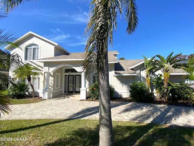 3 Tomoka View Dr, Ormond Beach, FL 32174 - view of front of home featuring stucco siding, french doors, and roof with shingles