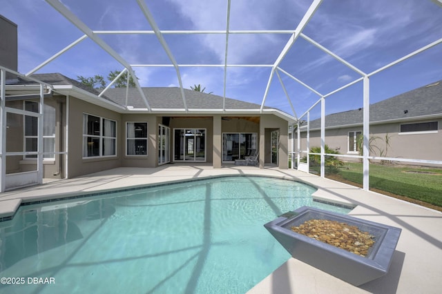 view of swimming pool with a patio, glass enclosure, a fire pit, and a fenced in pool