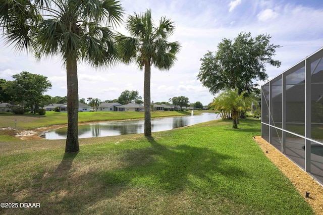 view of yard featuring a lanai and a water view