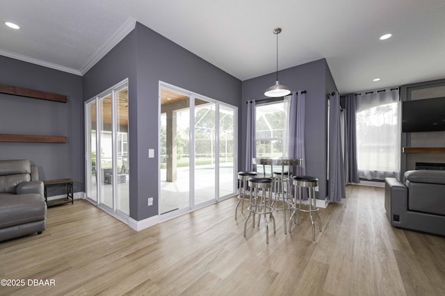 dining room with crown molding, baseboards, recessed lighting, and light wood-style flooring