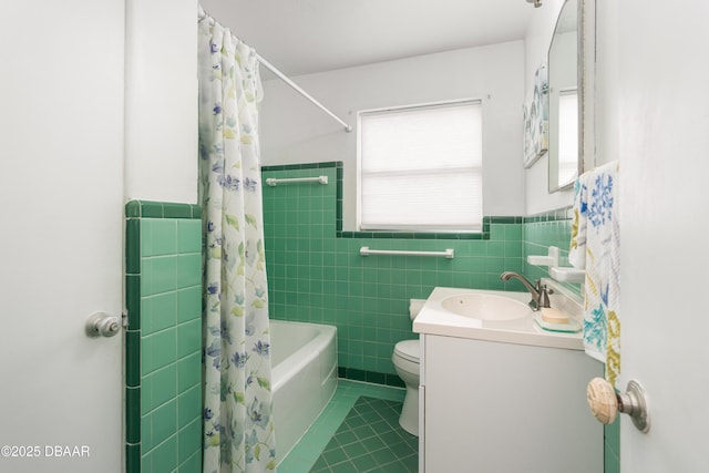 full bathroom with tile patterned floors, toilet, shower / tub combo, tile walls, and vanity