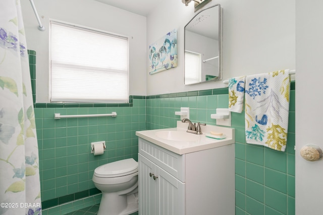 bathroom with vanity, curtained shower, tile walls, and toilet