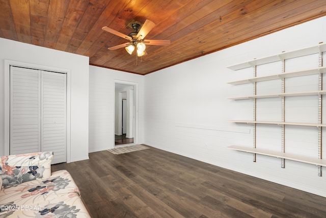 unfurnished bedroom featuring dark wood-type flooring, wooden ceiling, ceiling fan, and a closet