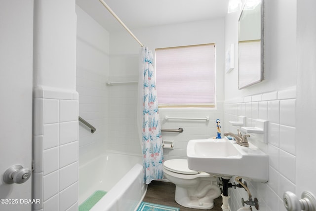 full bathroom featuring wood-type flooring, sink, tile walls, toilet, and shower / bath combo with shower curtain