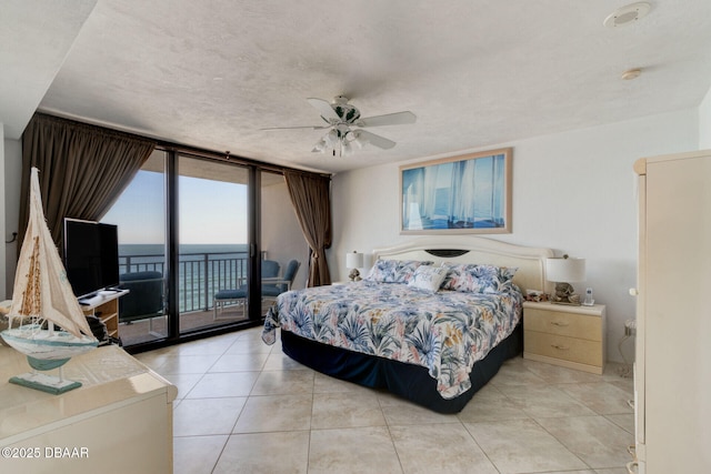 bedroom with light tile patterned floors, ceiling fan, expansive windows, and access to exterior