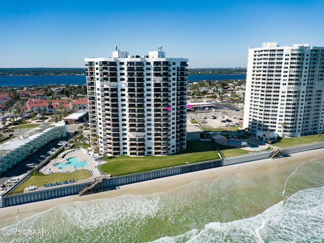 birds eye view of property with a water view and a beach view