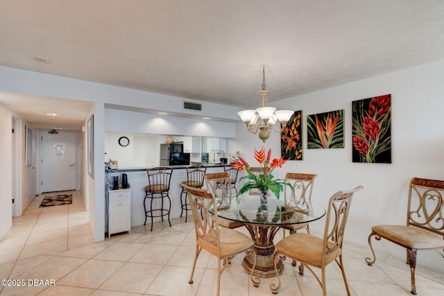 dining room with a notable chandelier, light tile patterned flooring, and visible vents