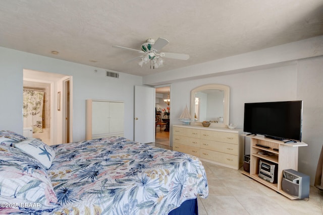 bedroom featuring visible vents, ceiling fan, ensuite bath, and light tile patterned flooring