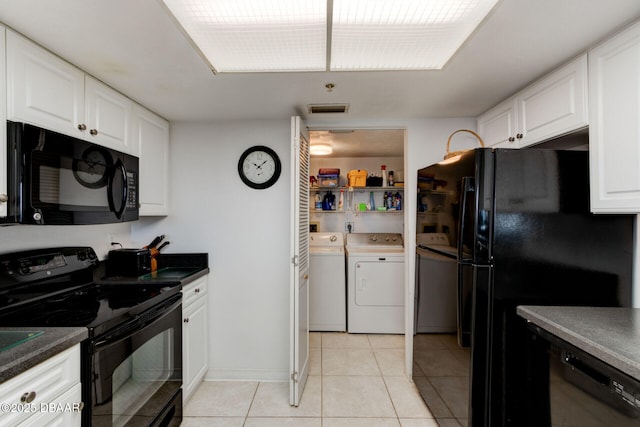 kitchen with visible vents, light tile patterned floors, black appliances, white cabinetry, and washer and dryer