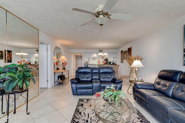 living area with ceiling fan with notable chandelier and light tile patterned floors