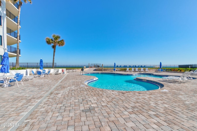 community pool featuring fence and a patio area