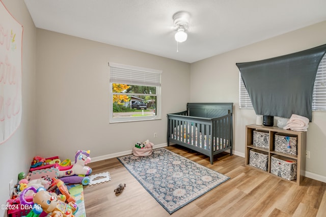 bedroom with a crib and wood-type flooring