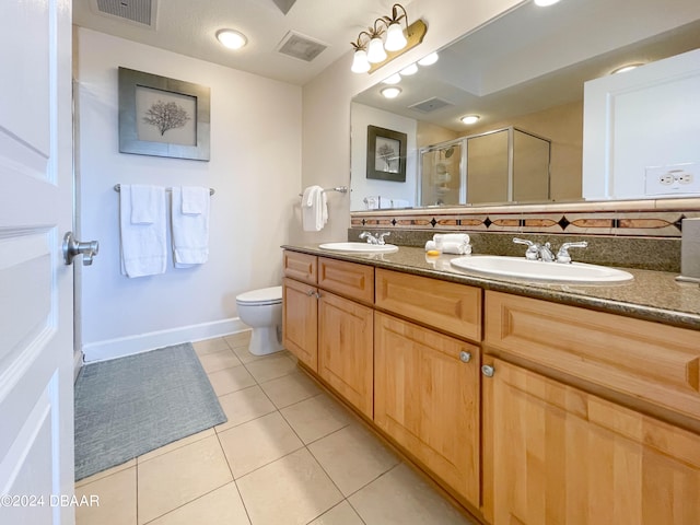 bathroom with backsplash, vanity, a shower with shower door, tile patterned floors, and toilet