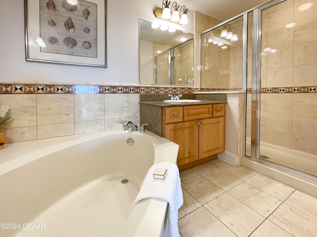 bathroom featuring tile walls, shower with separate bathtub, and vanity