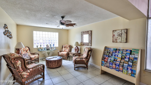 sitting room with a textured ceiling, ceiling fan, and light tile patterned flooring