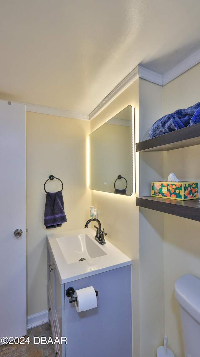 bathroom featuring toilet, vanity, and crown molding