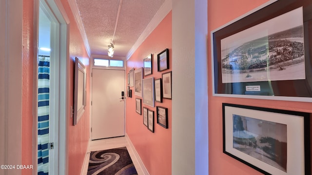 corridor with a textured ceiling and crown molding