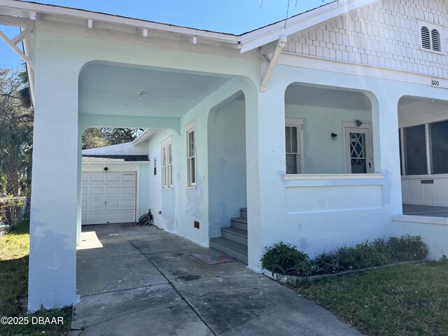 600 5th Ave, Daytona Beach, FL 32118 - view of side of home featuring stucco siding, driveway, and a garage