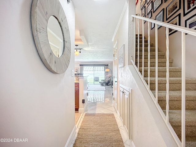 stairs featuring ornamental molding and tile patterned floors