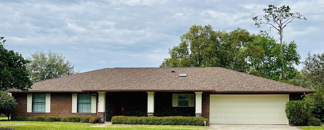 single story home featuring a garage, brick siding, roof with shingles, and driveway