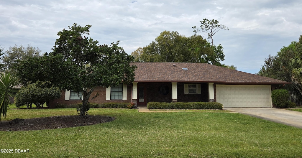 ranch-style home featuring a front yard, concrete driveway, brick siding, and a garage