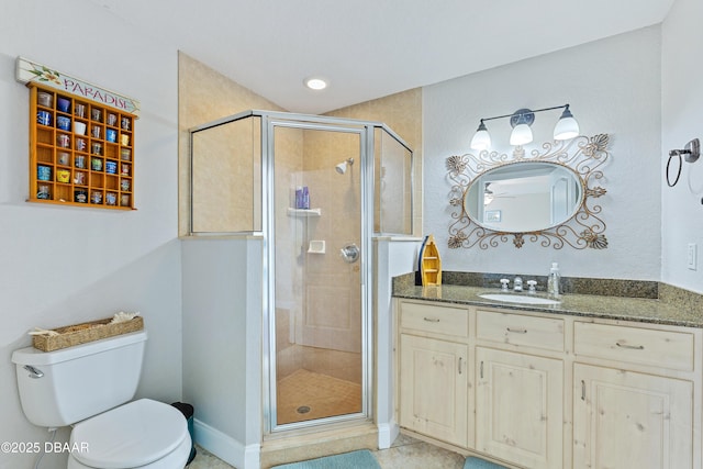 bathroom featuring tile patterned flooring, vanity, toilet, and walk in shower