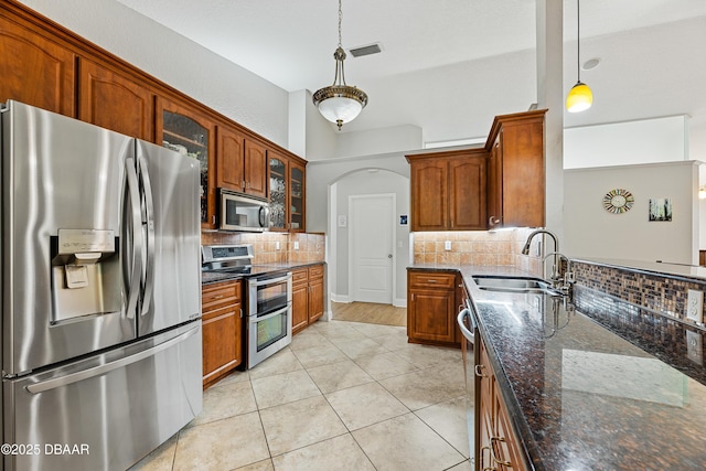 kitchen with sink, decorative backsplash, appliances with stainless steel finishes, decorative light fixtures, and light tile patterned flooring