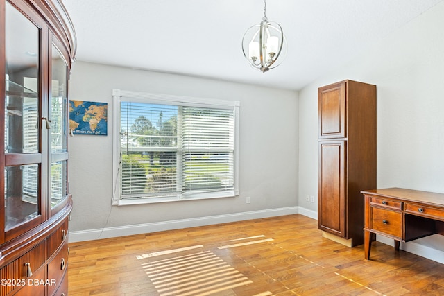 dining room featuring light hardwood / wood-style floors, lofted ceiling, and a notable chandelier