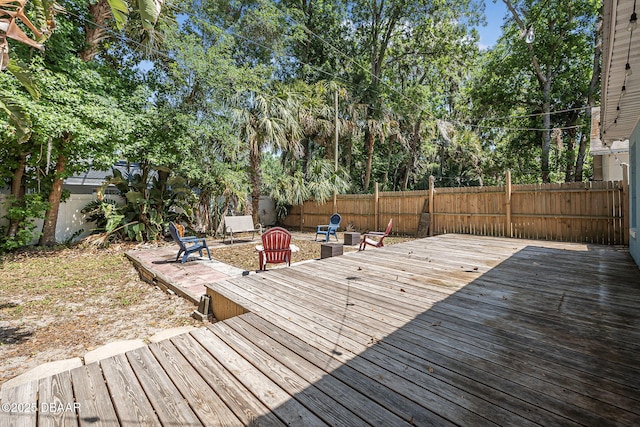 wooden deck with a fenced backyard