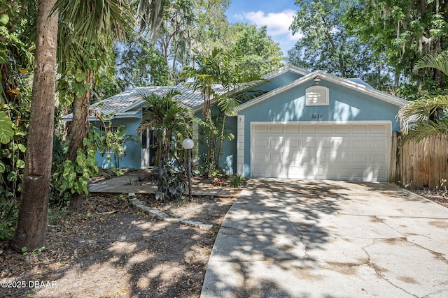 single story home featuring stucco siding, driveway, and a garage