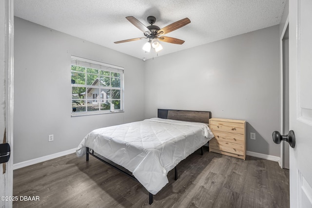 bedroom featuring baseboards, a ceiling fan, a textured ceiling, and wood finished floors