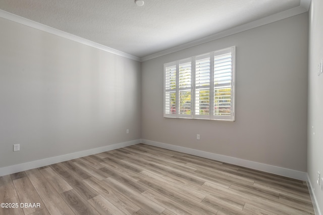 spare room with ornamental molding and light hardwood / wood-style flooring