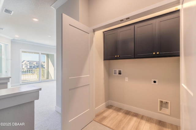 clothes washing area with cabinets, electric dryer hookup, ornamental molding, hookup for a washing machine, and light wood-type flooring