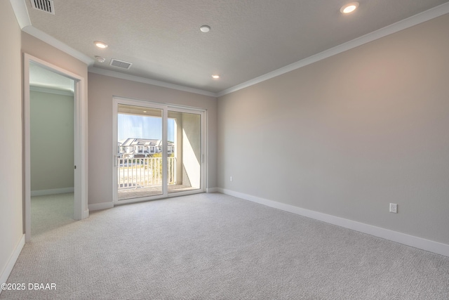 unfurnished room featuring a textured ceiling, light colored carpet, and ornamental molding