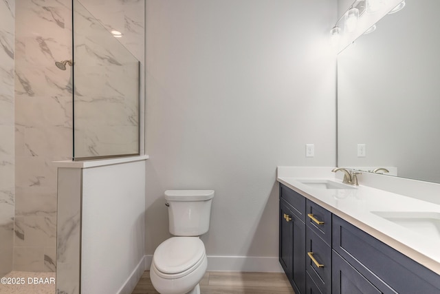 bathroom featuring tiled shower, vanity, and toilet