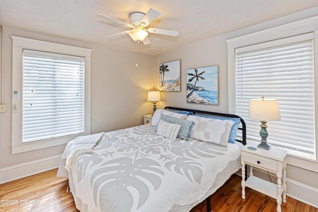 bedroom featuring ceiling fan, wood finished floors, and baseboards