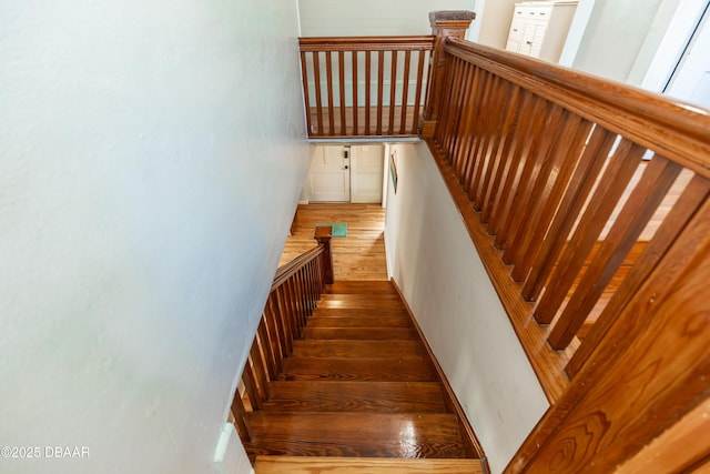 staircase with wood finished floors and baseboards