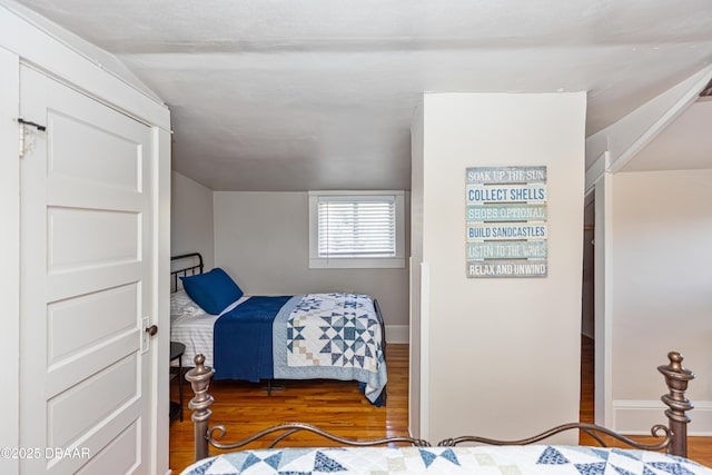 bedroom with baseboards and wood finished floors