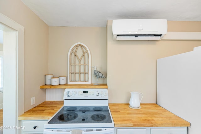 kitchen with butcher block countertops, electric range, and a wall unit AC