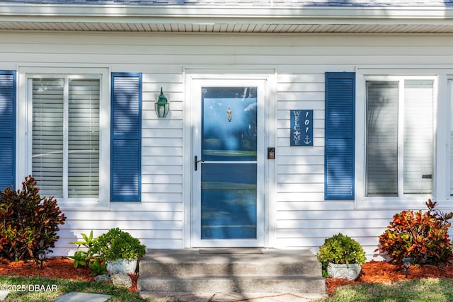 property entrance featuring a shingled roof