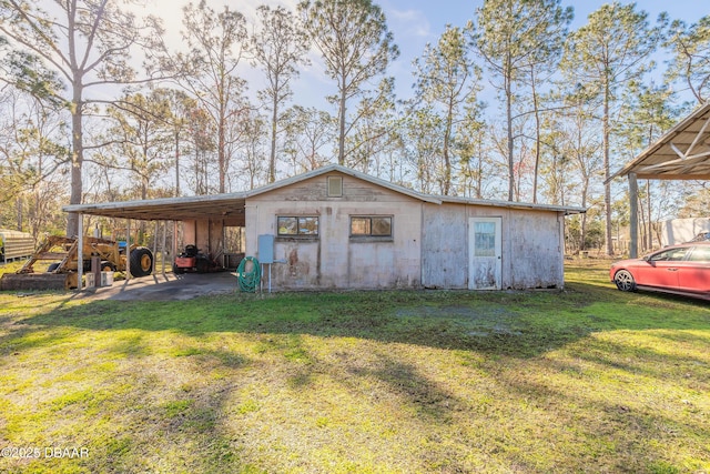 view of outbuilding featuring a carport and a lawn