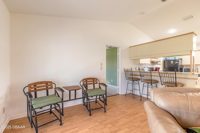 sitting room with vaulted ceiling and light hardwood / wood-style floors