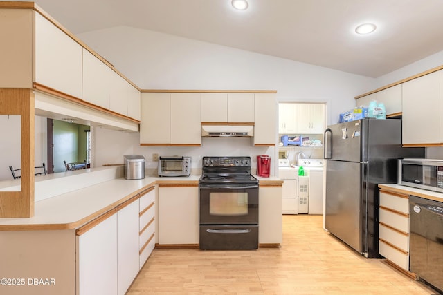 kitchen with lofted ceiling, black appliances, washer and dryer, white cabinets, and light wood-type flooring