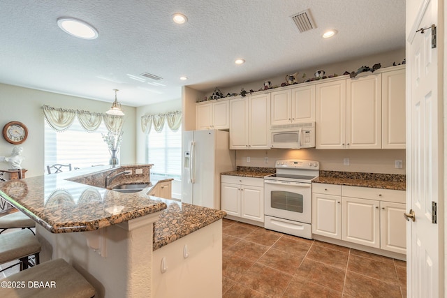 59 Westland Run, Ormond Beach, FL 32174 - kitchen with white appliances, a sink, a kitchen breakfast bar, a textured ceiling, and a kitchen island with sink