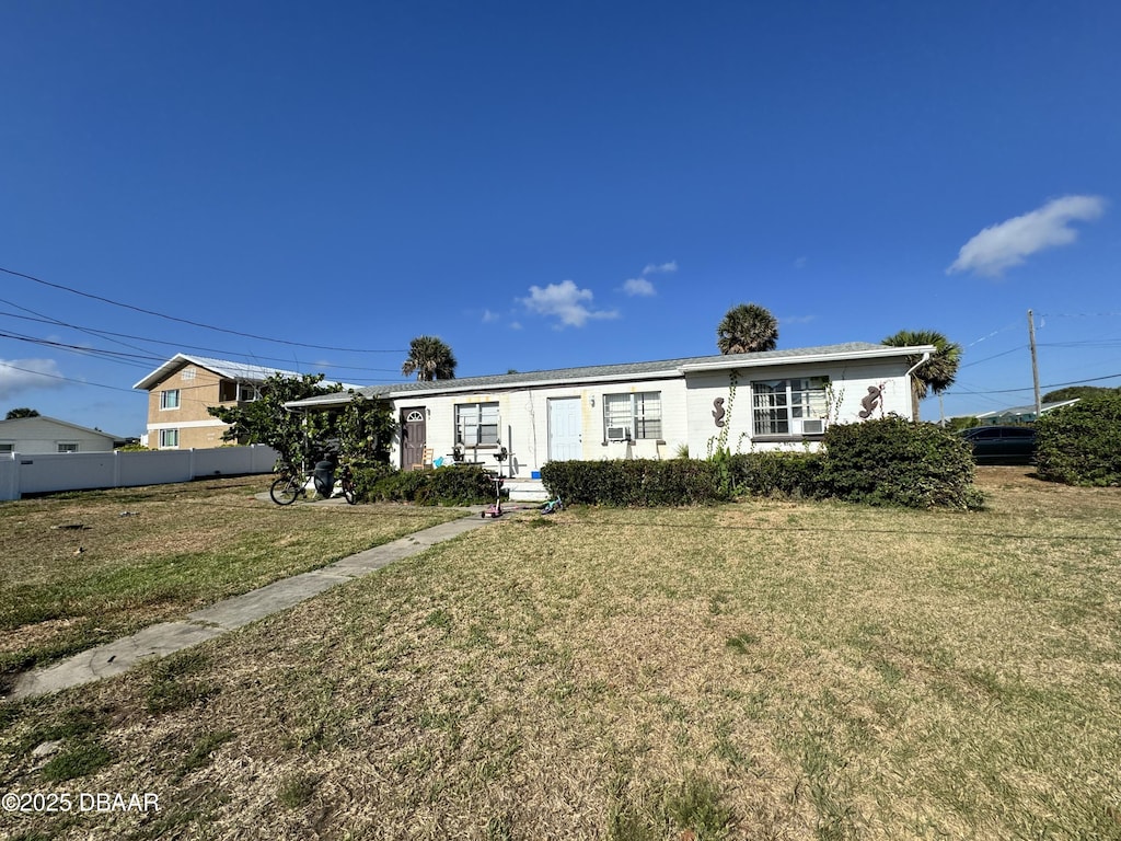 view of front of house with a front yard and fence